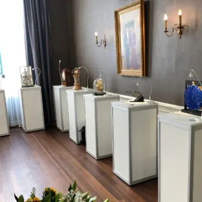 Expositie met witte zuilen en kubussen