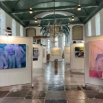 Expositie met witte wanden in een kerk