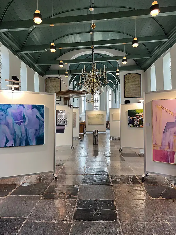 Expositie met witte wanden in een kerk