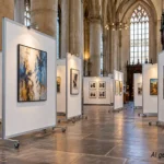 Expositie op witte mobiele wanden in kerk